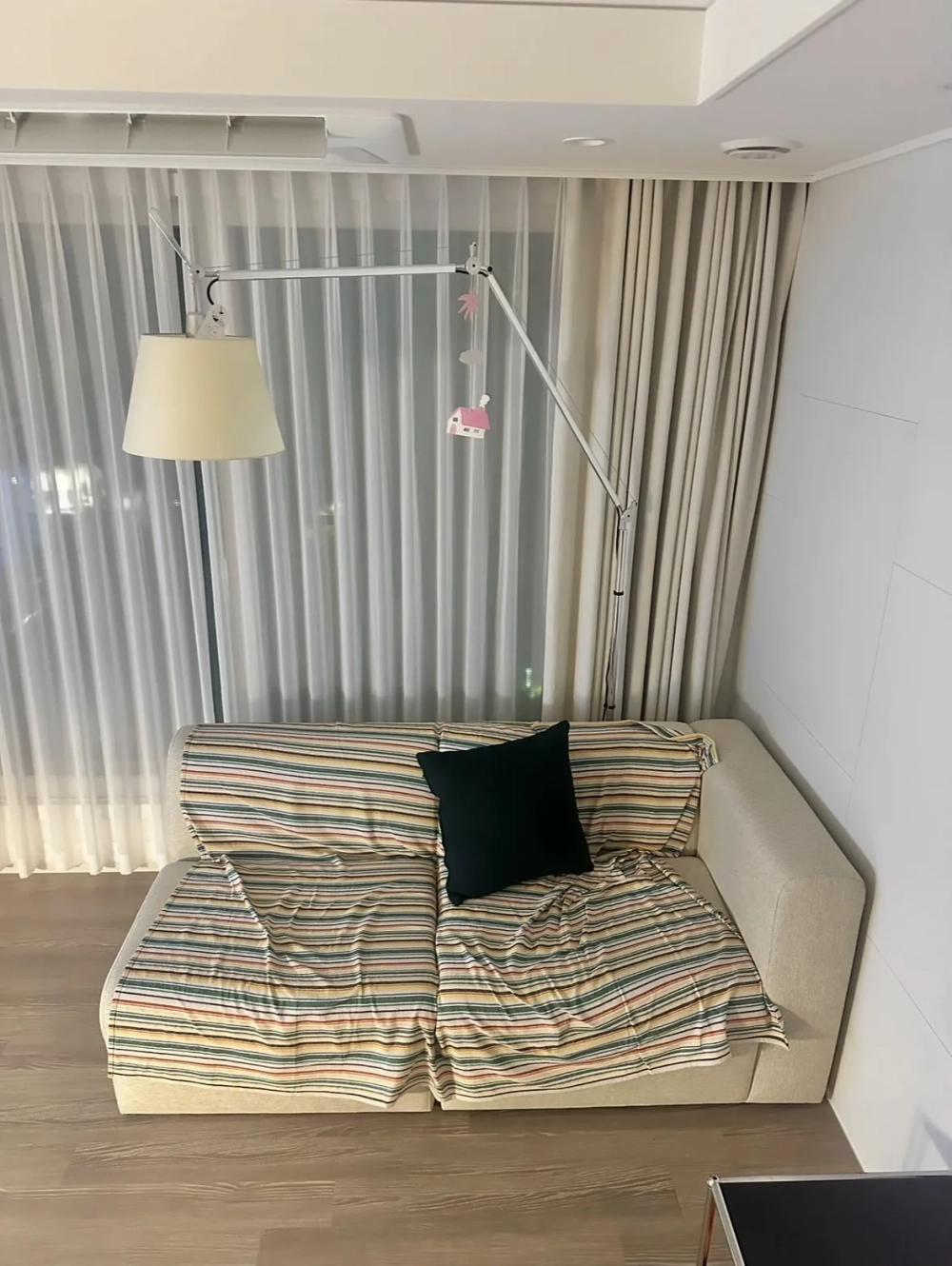 Bộ sofa góc chữ L màu trung tính đặt sát góc tường giúp tiết kiệm diện tích phòng khách